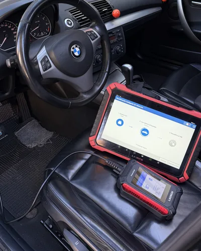 Escáner Launch y su módulo inalámbrico sobre el asiento de un BMW Serie 1